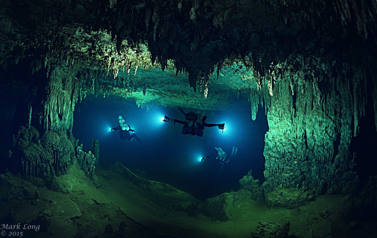 Three divers with torches in Giant Cave, Belize 2015